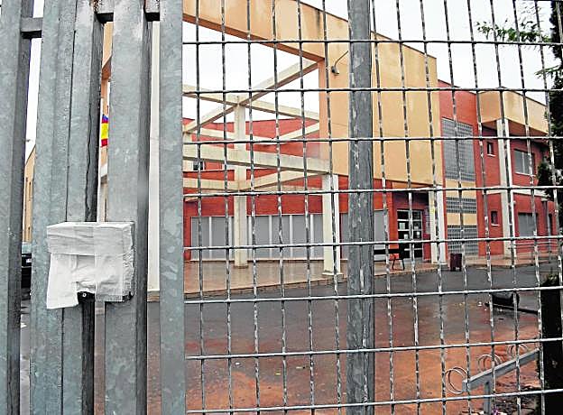 Puerta de acceso al Instituto Galileo de Pozo Estrecho, con el fono puerta roto y en el interior una papelera tirada. 