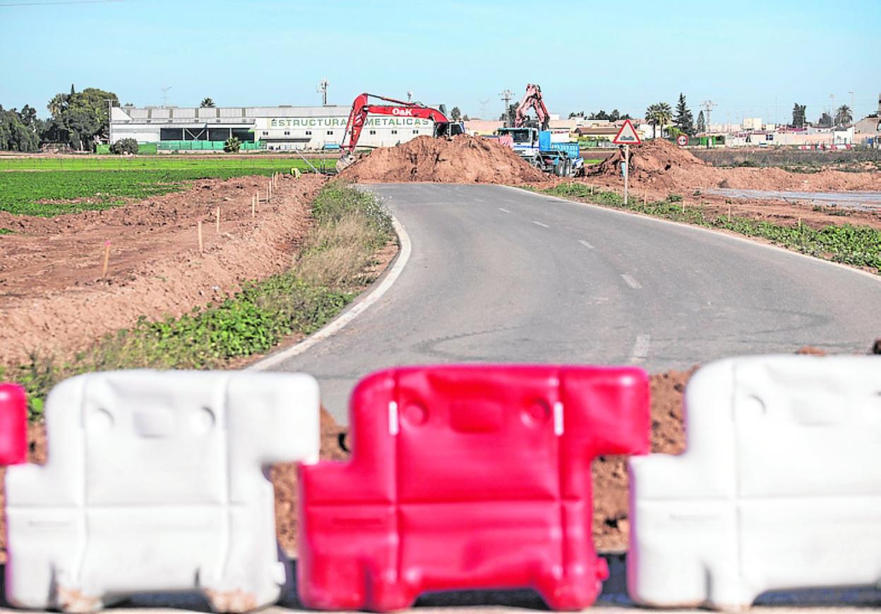 Una pala hace una zanja, en la carretera RM-E33. 