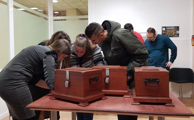 Varios jóvenes tratan de resolver 'El reto de las tres cajas'. 