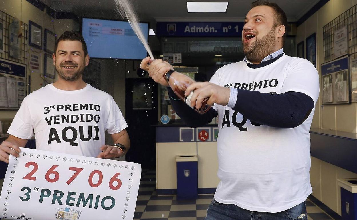 Varias personas festejan el tercer premio del Sorteo extraordinario de El Niño, el 26706, en Torrent, Valencia.