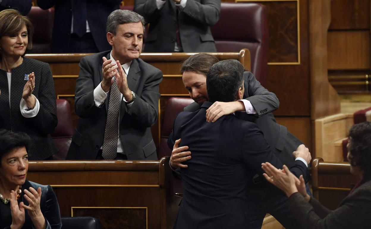 Pedro Saura aplaude en el Congreso mientras Pedro Sánchez y Pablo Iglesias se abrazan en la sesión de investidura.