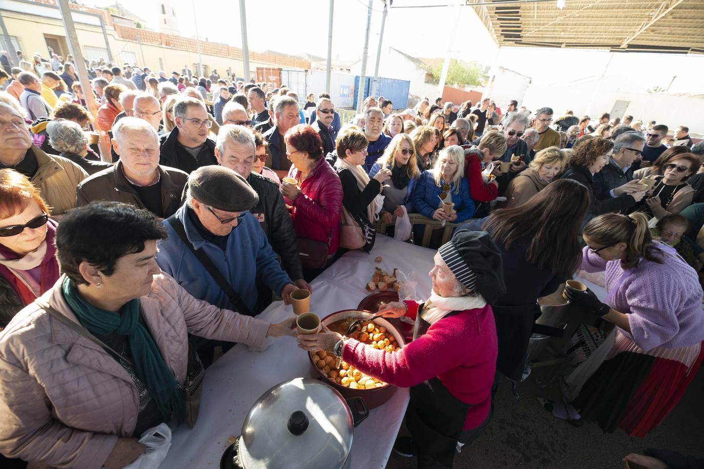 Decenas de personas se agolpan junto a las barras, donde amas de casa y peñistas sirven las típicas pelotas galileas