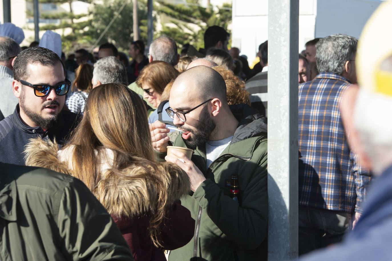 Decenas de personas se agolpan junto a las barras, donde amas de casa y peñistas sirven las típicas pelotas galileas