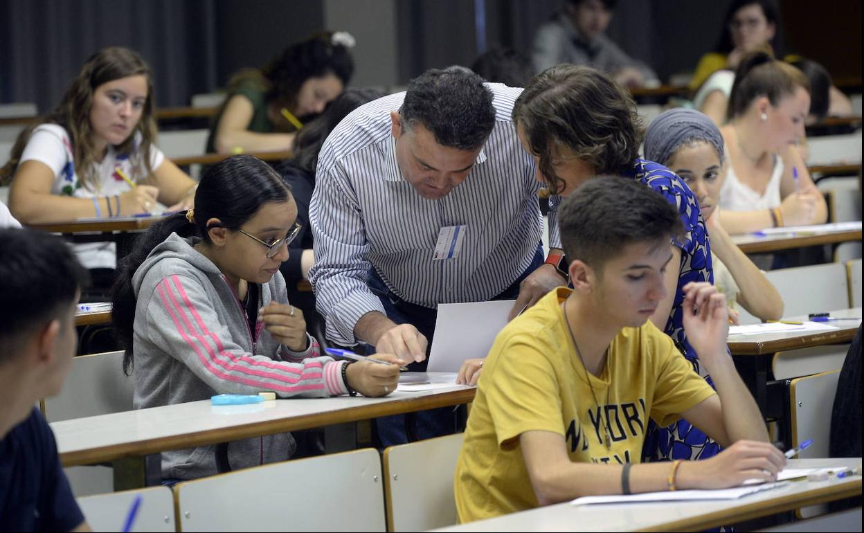 Una alumna consulta una duda a dos profesores durante un examen de la pasada selectividad.