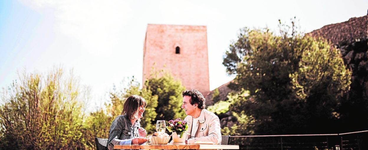 Una pareja toma un aperitivo en la cafetería Las Caballerizas del Castillo de Lorca. 