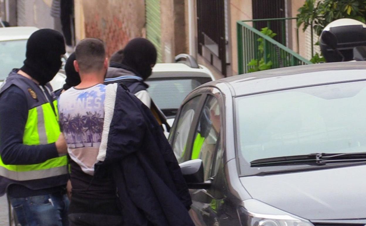 Policías trasladan a uno de los sospechosos, tras su arresto. 