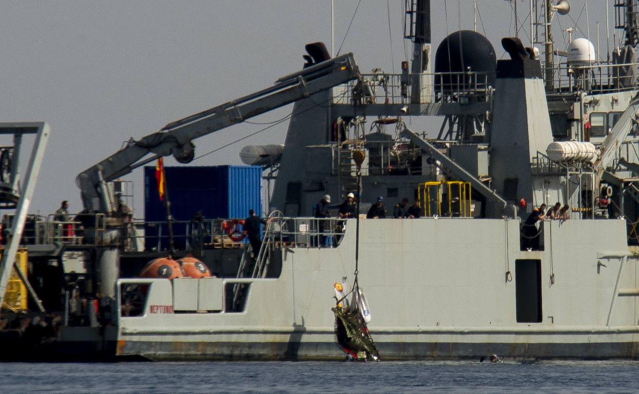 Una de las embarcaciones que participa en las labores de rescate retira restos del fuselaje del avión accidentado este jueves frente a La Manga. 