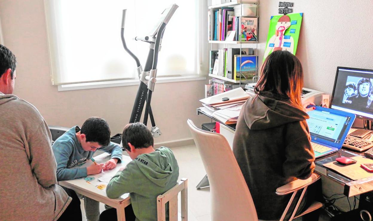Carmen y Manuel comparten espacio de trabajo con sus dos hijos, que realizan los deberes mientras ellos tratan de adelantar sus tareas laborales.