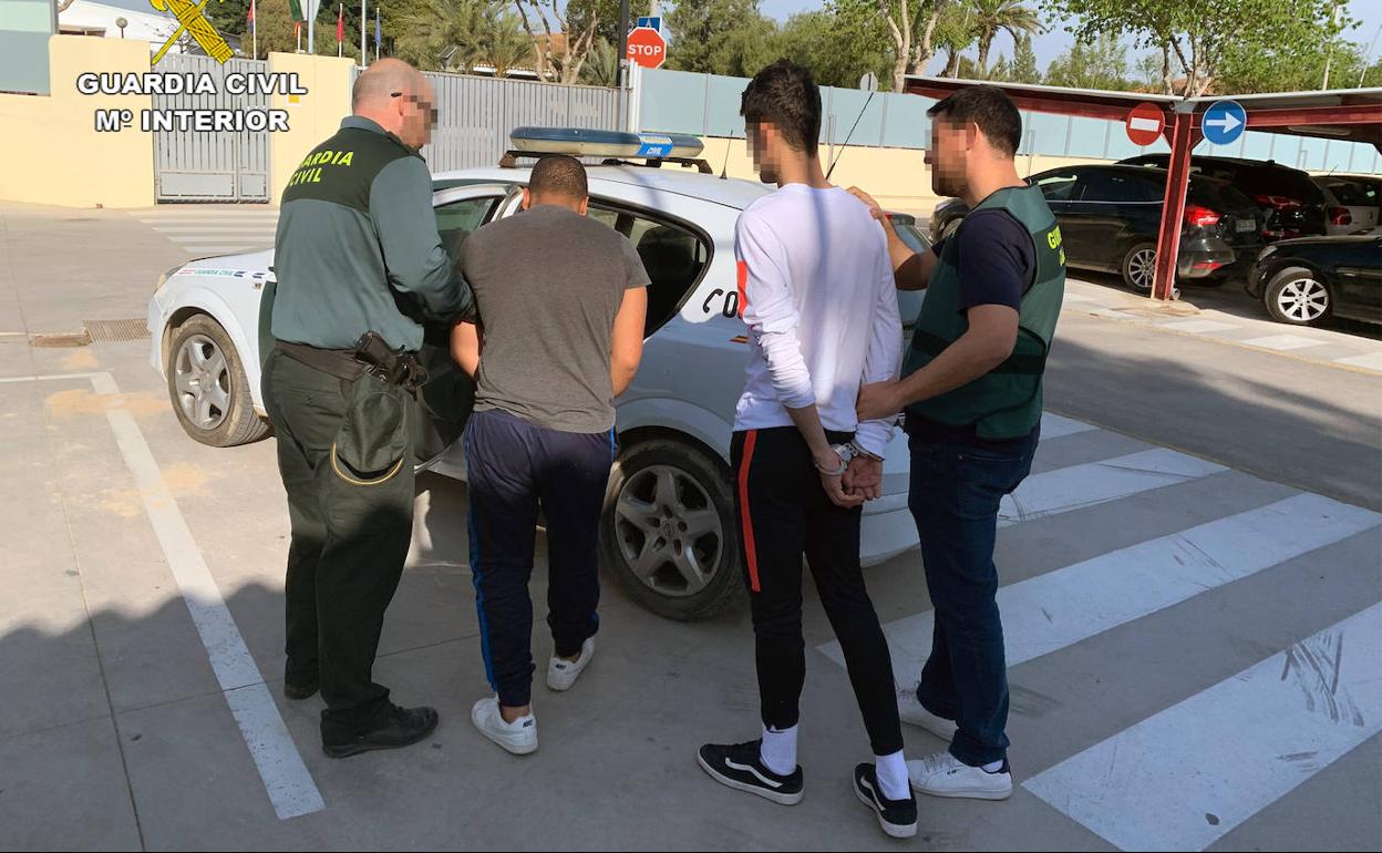 Dos agentes, con los dos detenidos en la operación. 