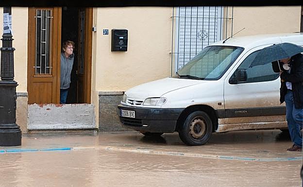 Una vecina se asoma a la calle, con la puerta tabicada. 