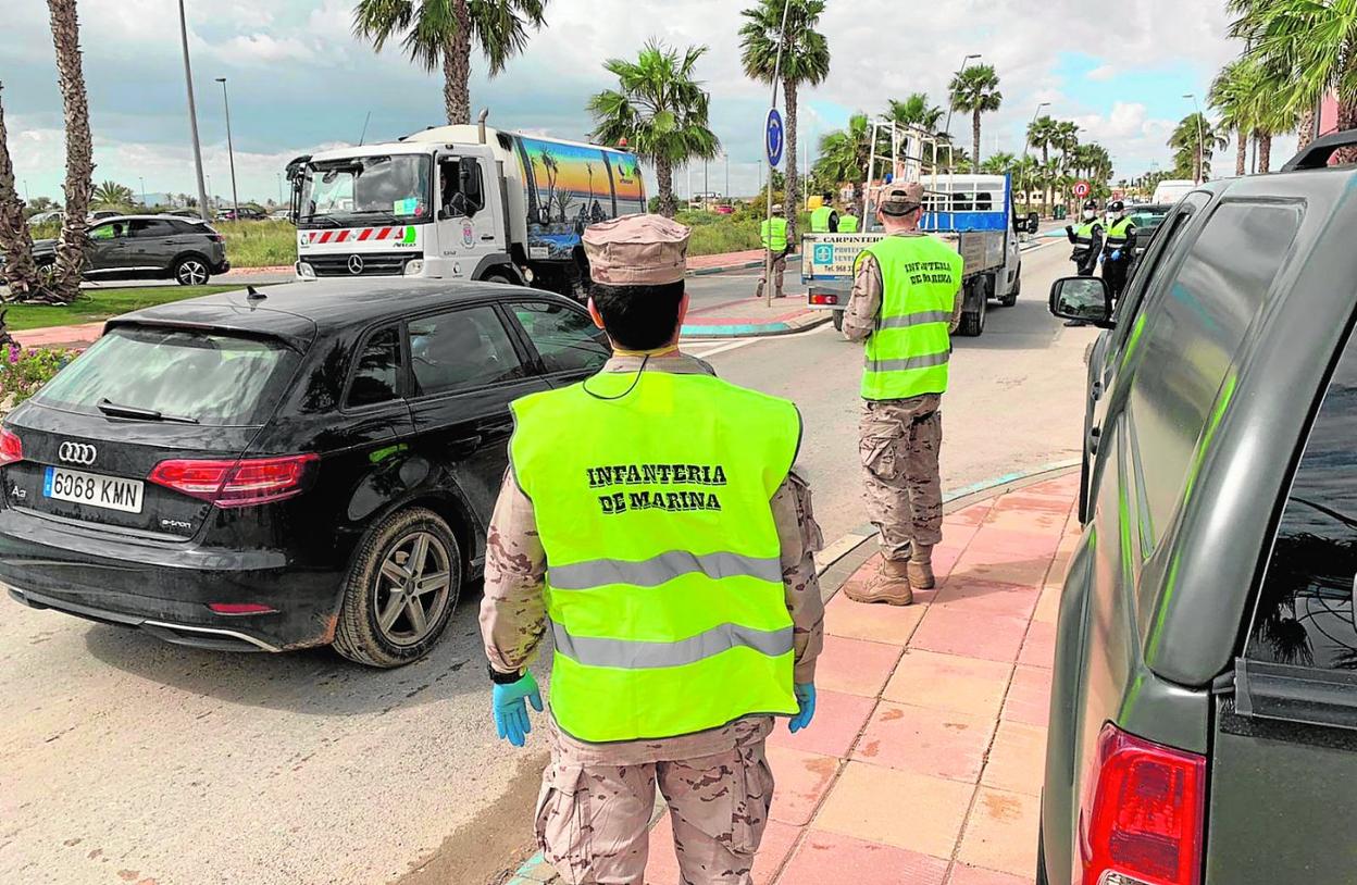 Militares y policías controlan el tráfico en una calle de Los Alcázares, ayer por la mañana. 