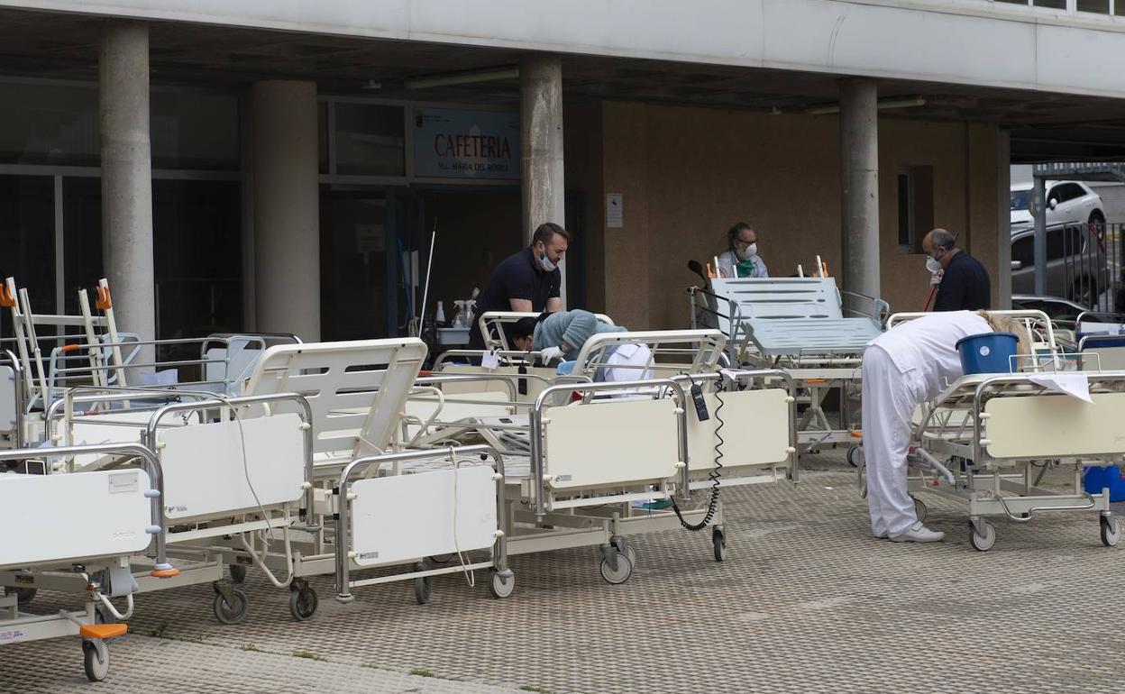 Empleados del Rosell limpian camas sacadas del almacén para ponerlas en uso. 