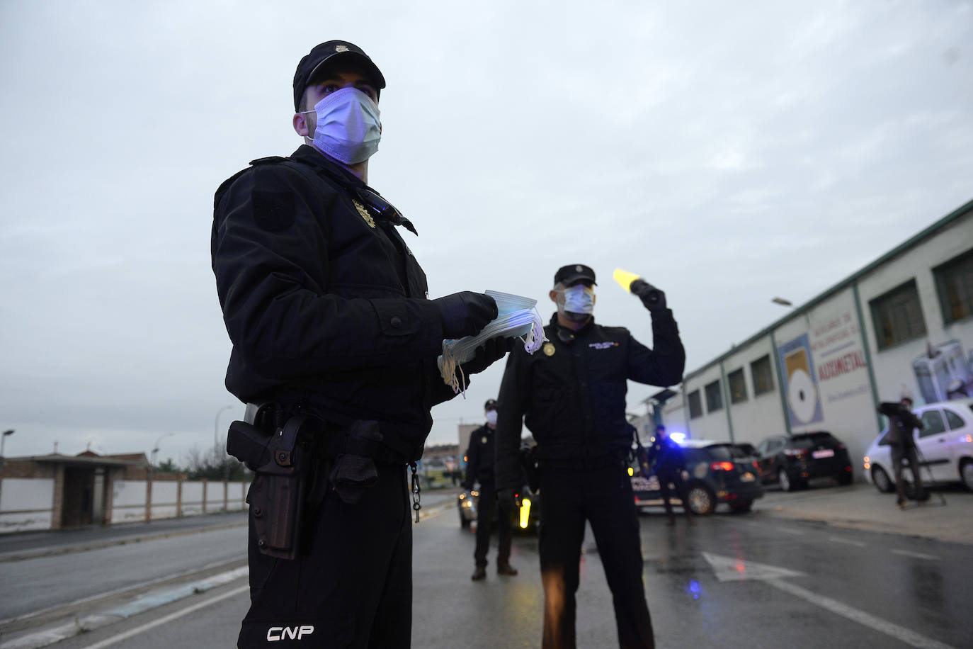 Agentes de policía reparten masacarillas en los accesos del Polígono Oeste de Murcia.