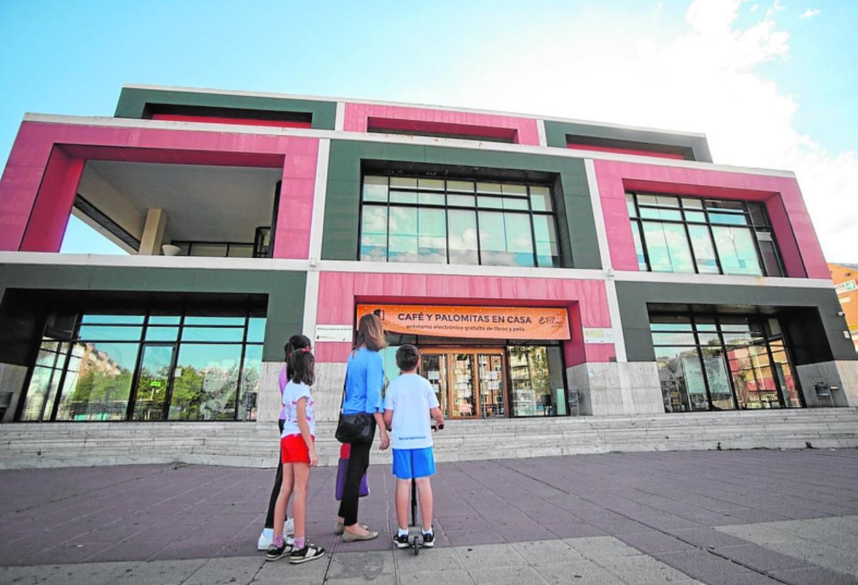 Una familia frente a la puerta de la Biblioteca Regional, cerrada. 