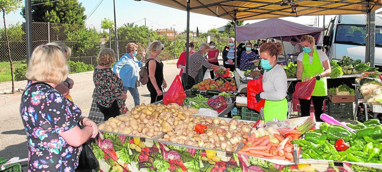 Clientela frente a un puesto de verduras instalado el pasado lunes en la pedanía murciana de Algezares, día en el que los mercadillos volvieron a la actividad. 
