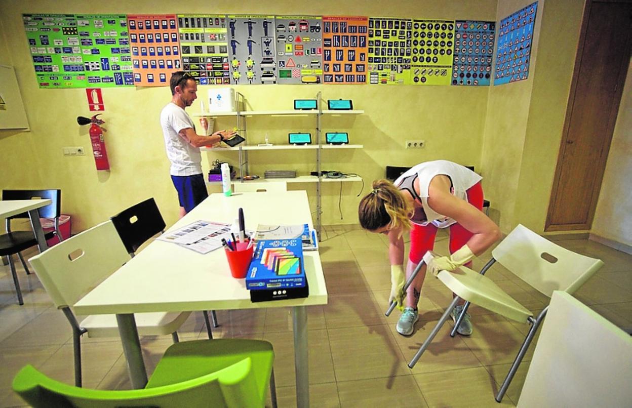 Yolanda y Antonio limpian el aula de su autoescuela. 