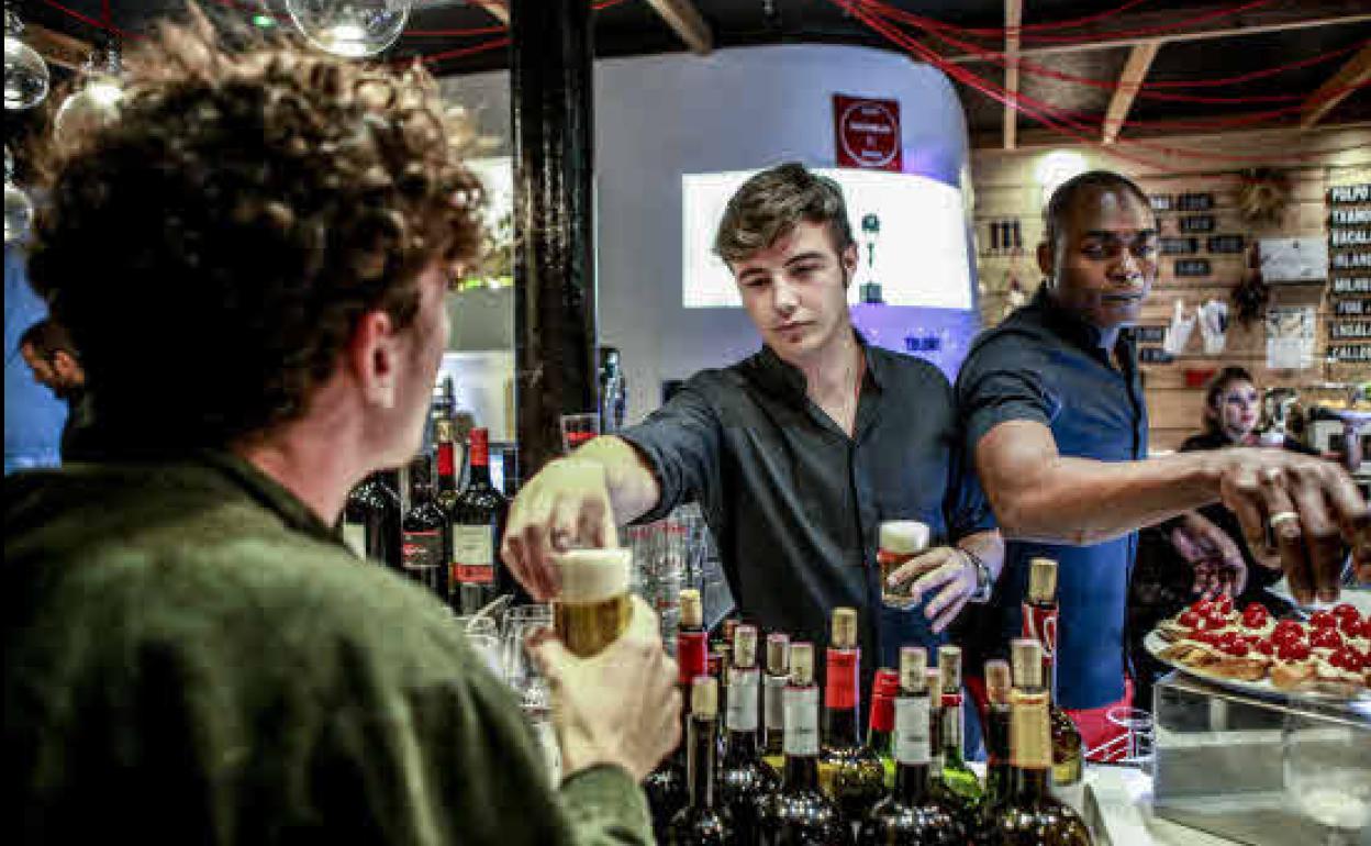 Dos jóvenes trabajando en un bar.