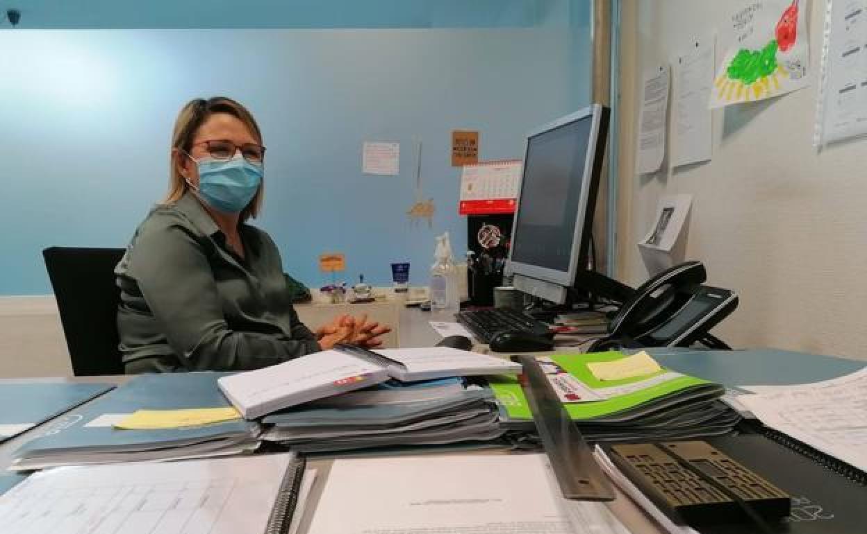 Una funcionarioa trabajando con mascarilla.