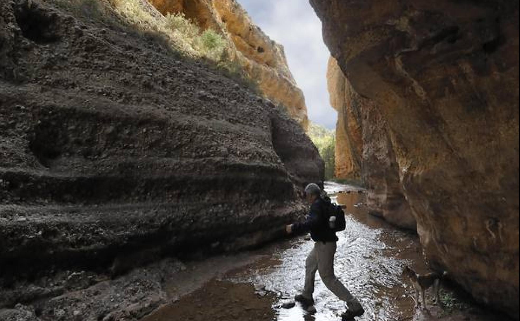 Un excursionista cruza el río Chícamo, en Abanilla.