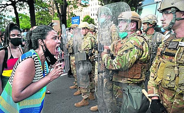 Imagen principal - Una manifestante ante la Casa Blanca en Washington se encara con los militares colocados ante la protesta. | Manifestante con una mascarilla con las últimas palabras de Floyd: 'No puedo respirar'. | El policía Derek Chauvin mantuvo inmovilizado así a George Floyd durante más de ocho minutos, hasta que murió.