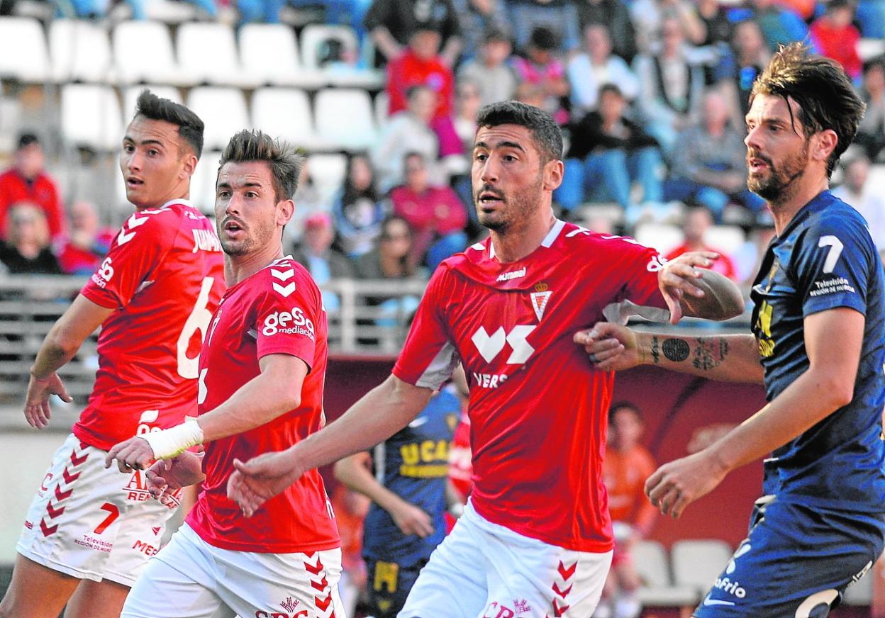 Dani Segovia, del UCAM, forcejea con Antonio López en el útimo derbi capitalino; a la izquierda, Chumbi y Juanma, el pasado 23 de febrero.