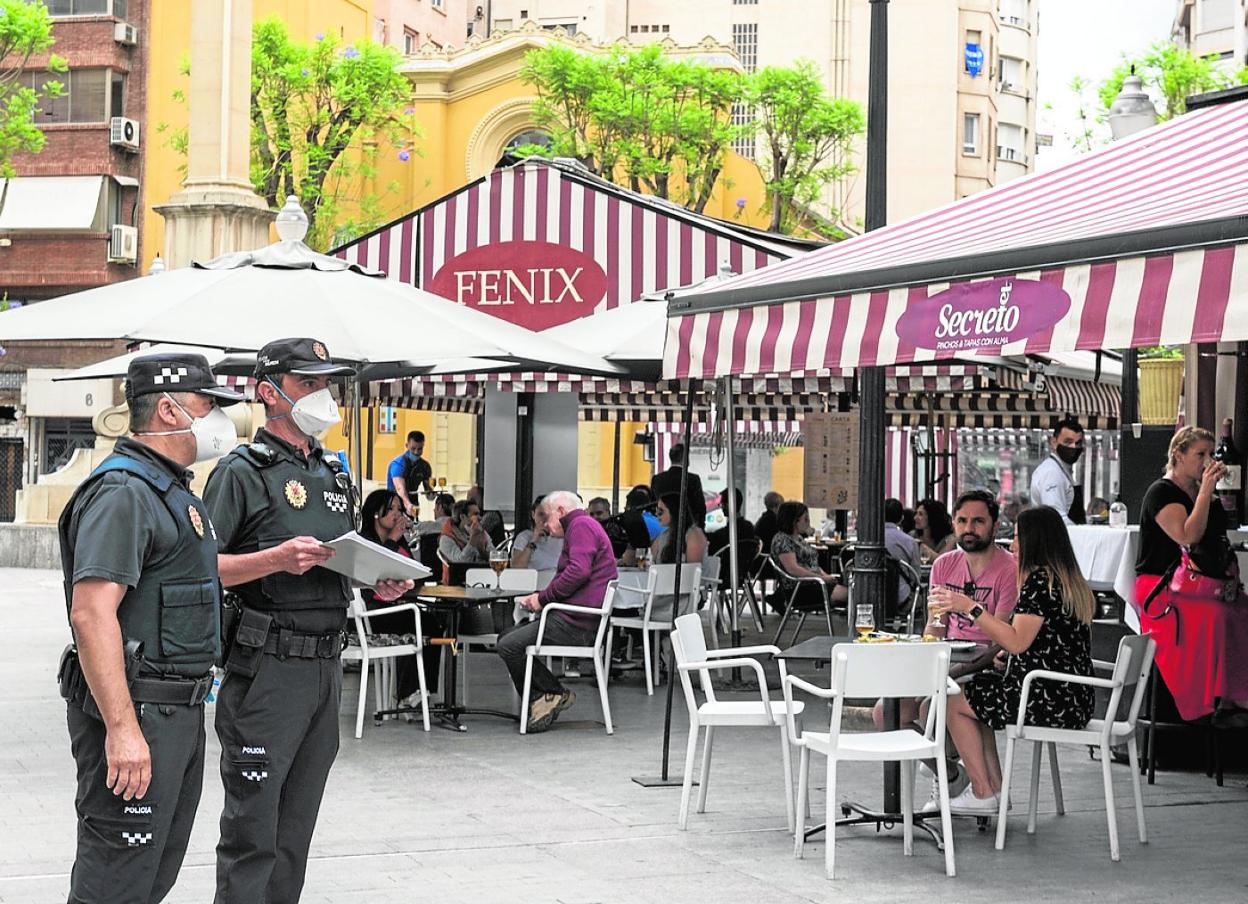 Dos agentes de la Policía Local supervisan las terrazas de la plaza de las Flores de Murcia. 