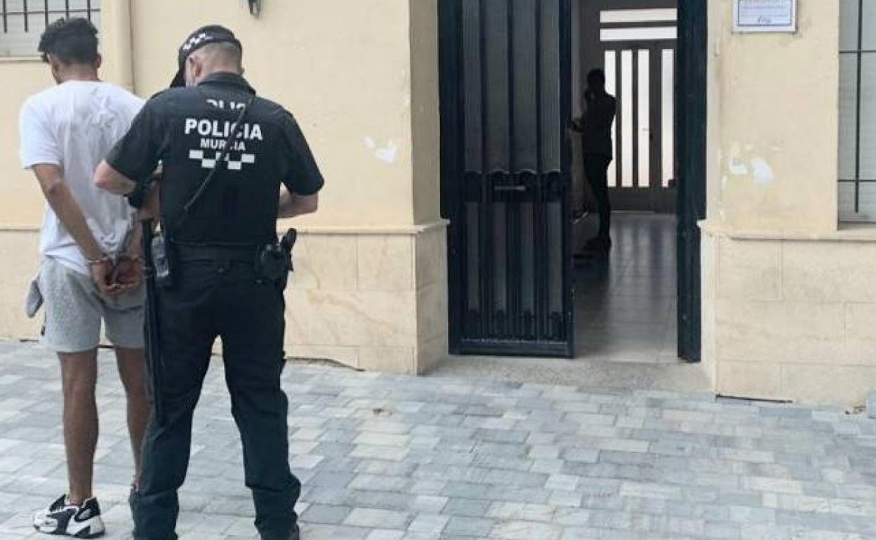 Un agente de la Policía Local de Murcia junto al detenido.