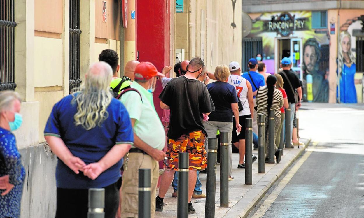 Varias personas hacen cola para recoger comida en Jesús Abandonado, este mes. 