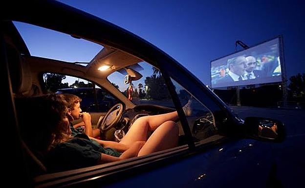 Galería. Una mujer y su hijo ven la película sentados en su coche, anoche en La Fica.