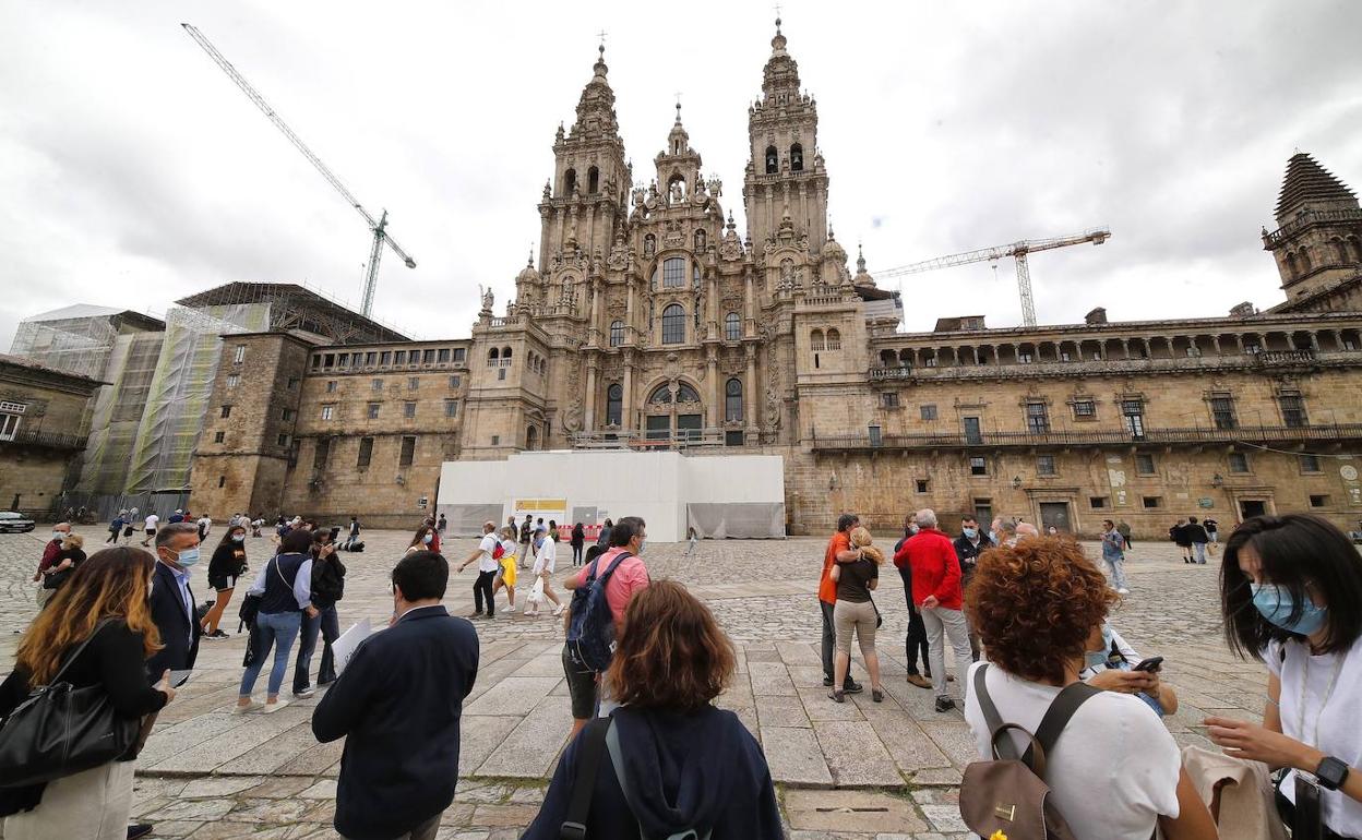 Unos turistas se agrupan a las puertas de la catedral compostelana. 