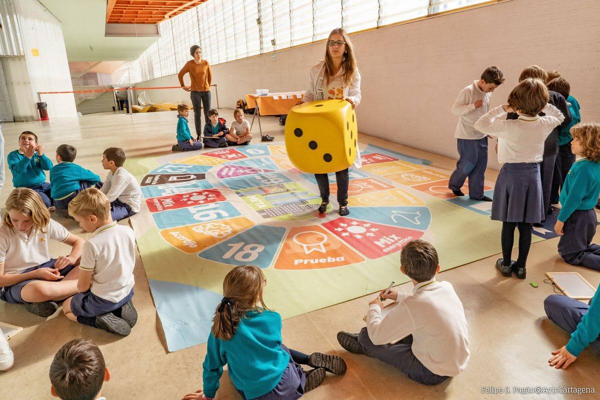 Una maestra juega con los alumnos de un colegio. 