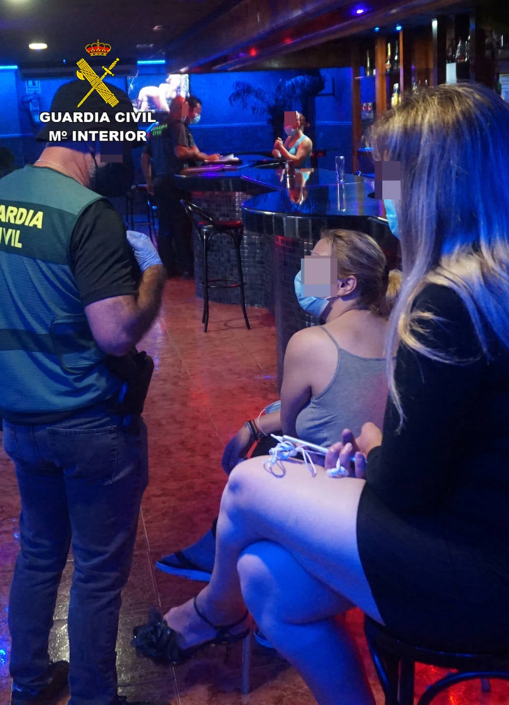 Imagen secundaria 1 - Un agente con una de las mujeres del local y la droga encontrada en una arqueta.