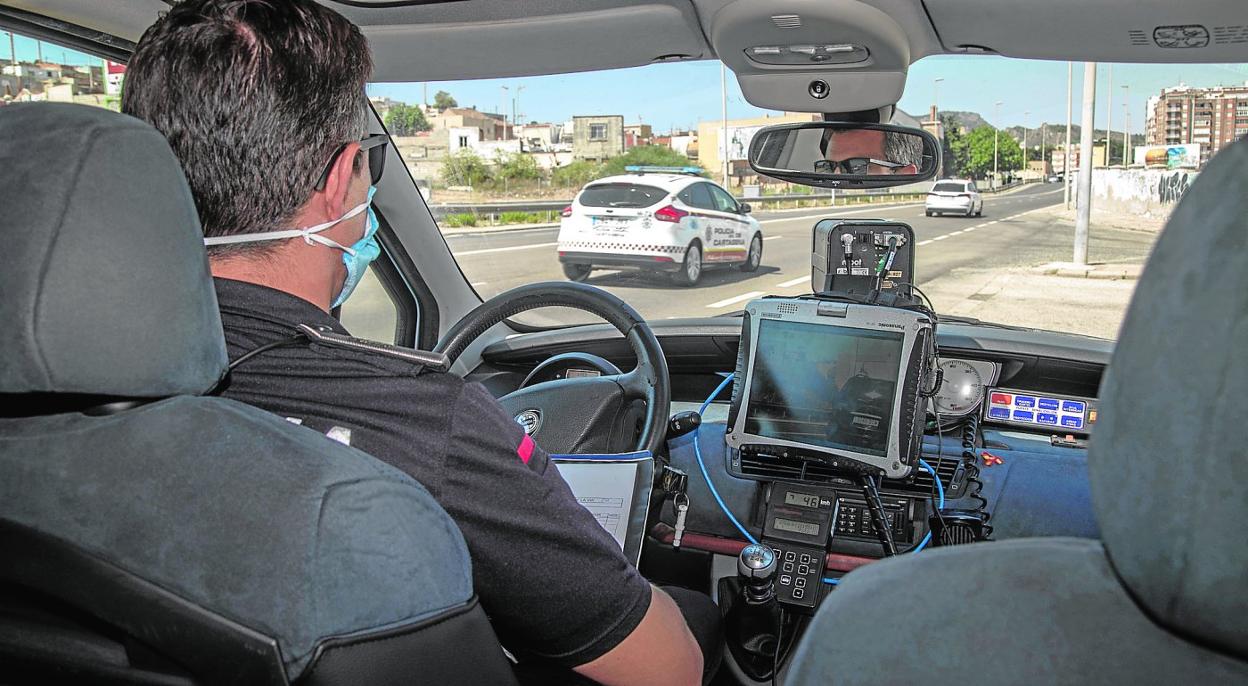 Un agente, a bordo de un vehículo radar de control de velocidad, ve pasar un coche de la Policía Local mientras mide el tráfico en la carretera de La Unión. 