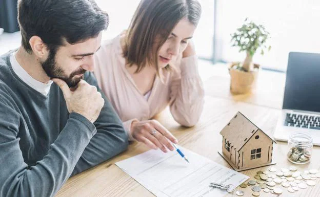 Una pareja echa cuentas para la hipoteca de su casa. 