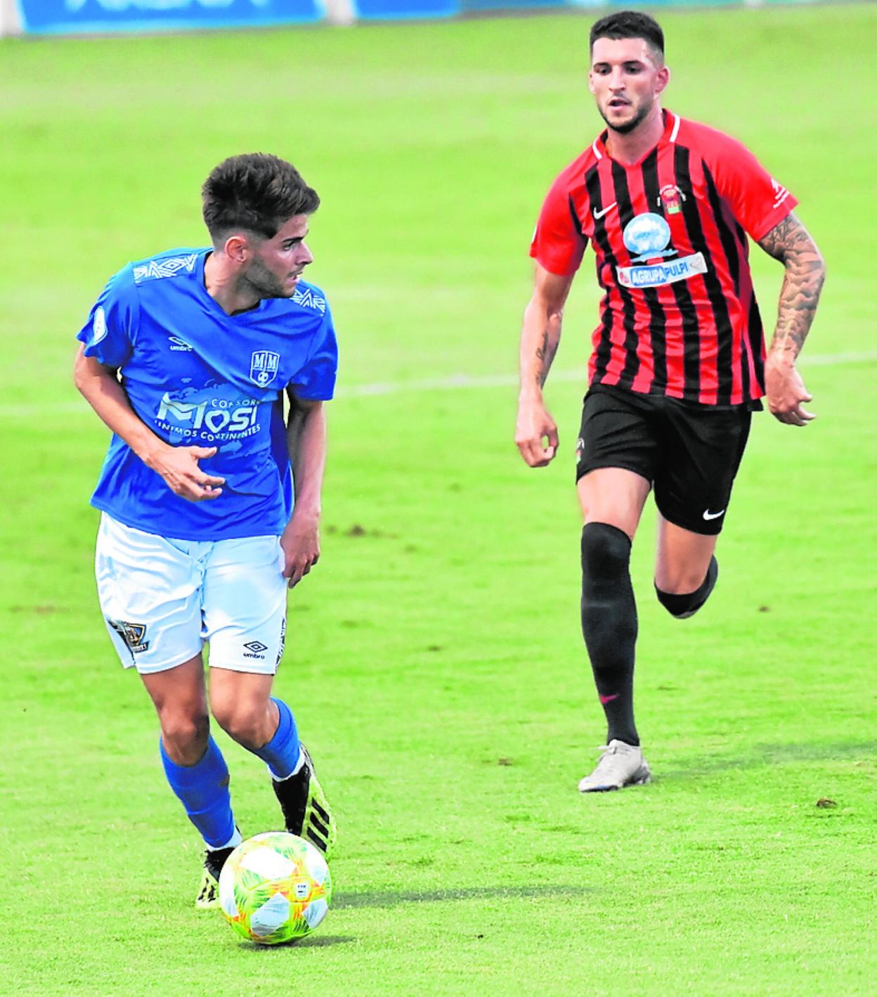 Nacho López, del Mar Menor, controla el balón, perseguido por un rival. 