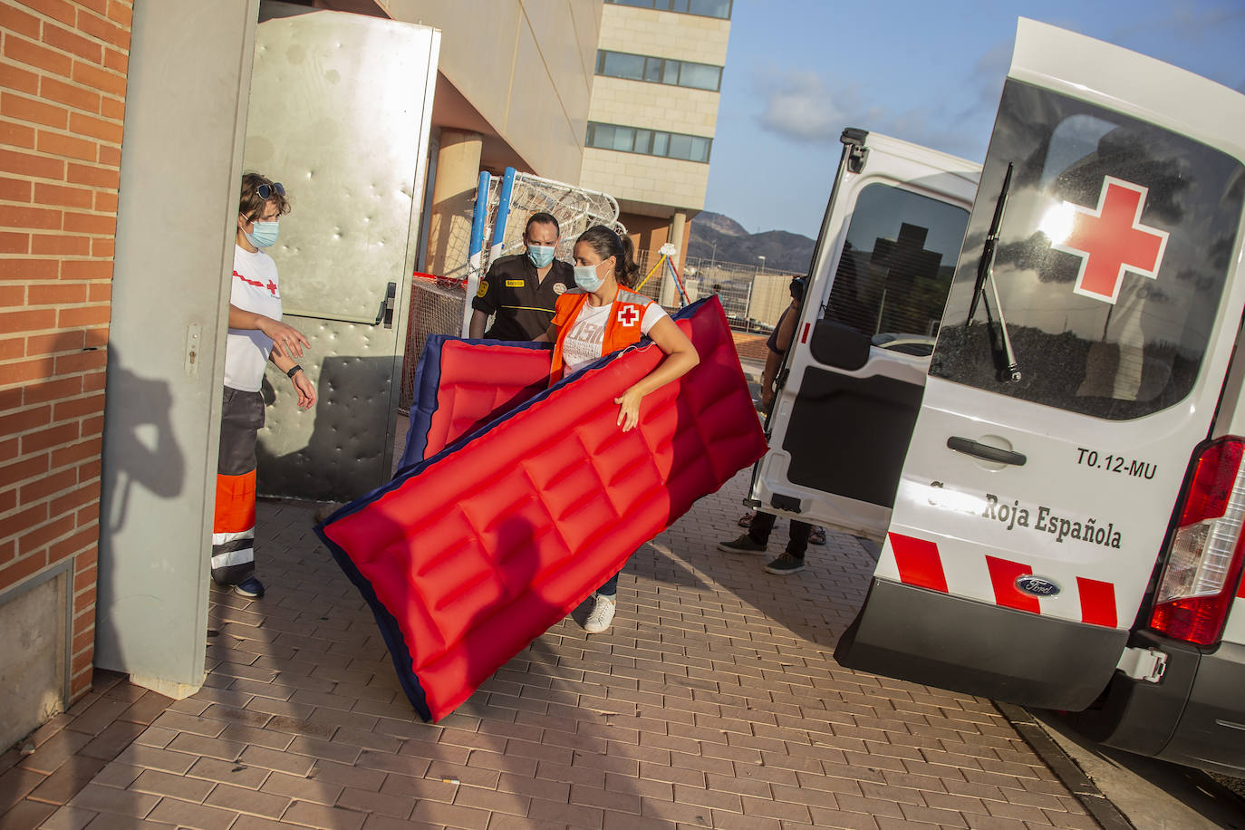 Fotos: Traslado de los inmigrantes en cuarentena al pabellón de Cabezo Beaza