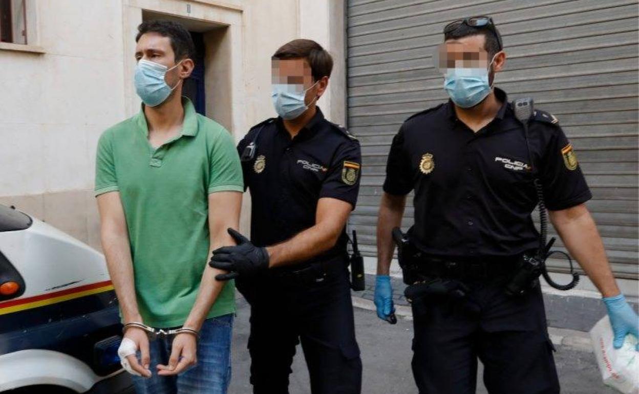 Dos agentes de la Policía Nacional trasladan a un centro hospitalario al presunto parricida, este miércoles.