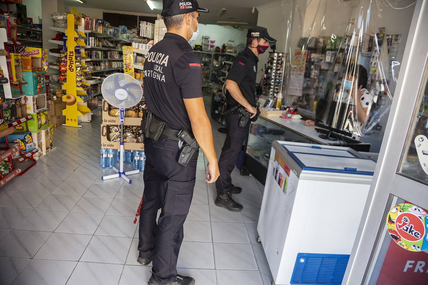 Dos agentes de la Policía Local de Cartagena, este miércoles en un comercio de Barrio Peral.