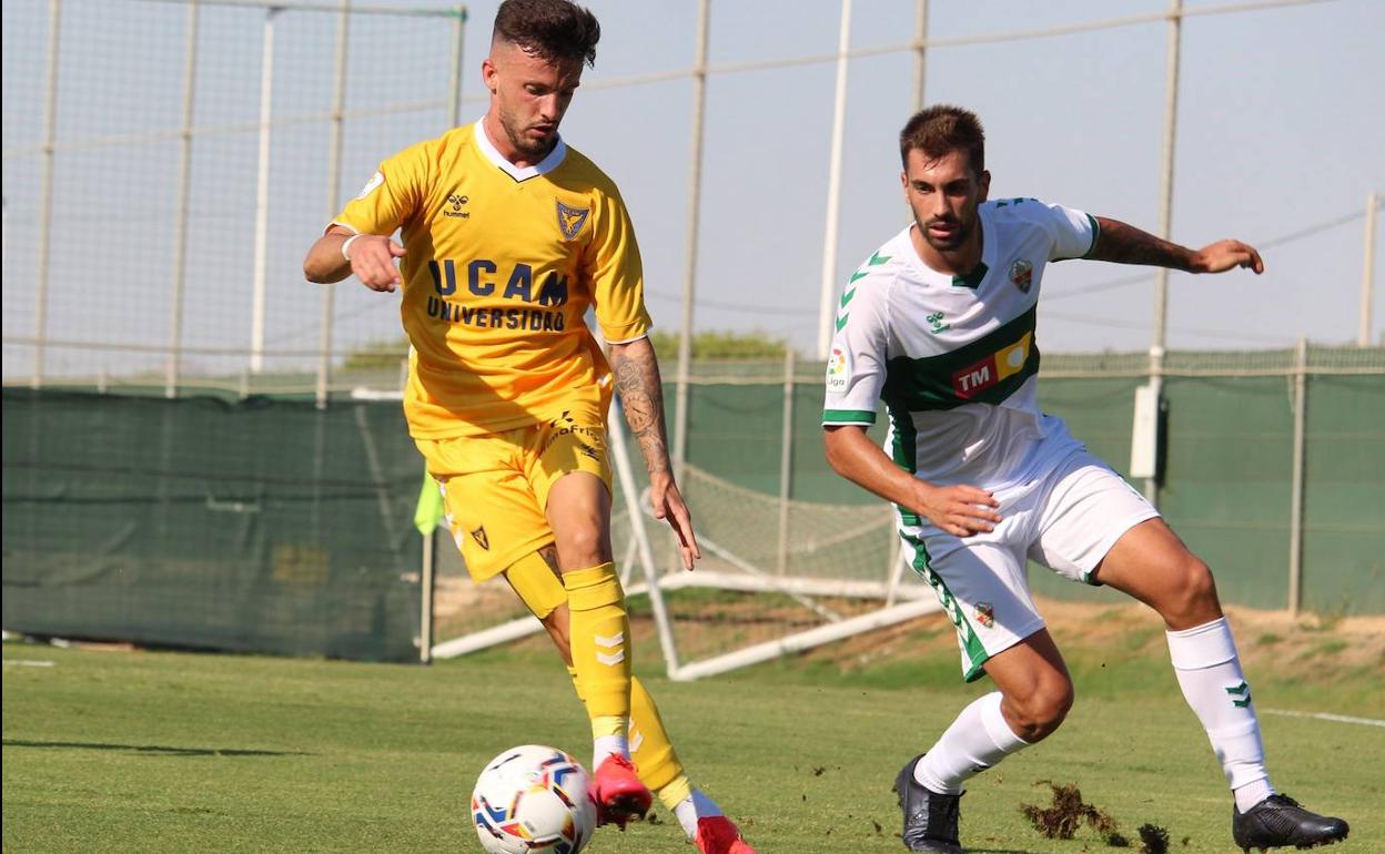 Javi Moreno controla el balón con Josema encima de él.