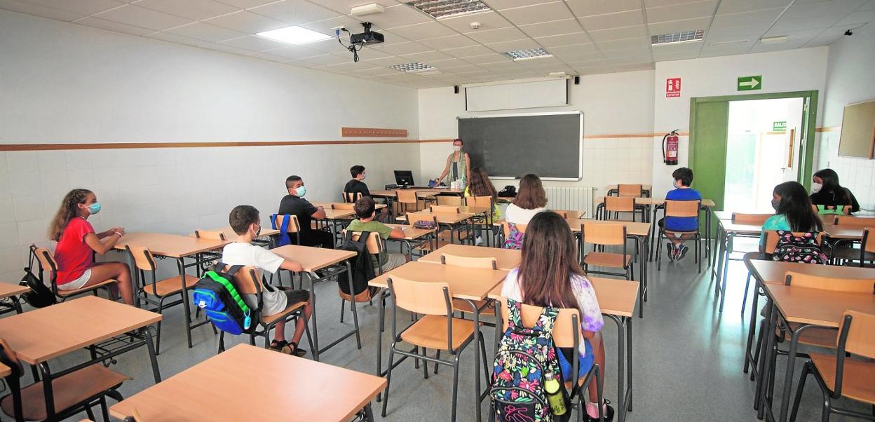 Una de las aulas del instituto Alfonso X de Murcia, con los alumnos separados por pupitres vacíos y con la mascarilla puesta. 