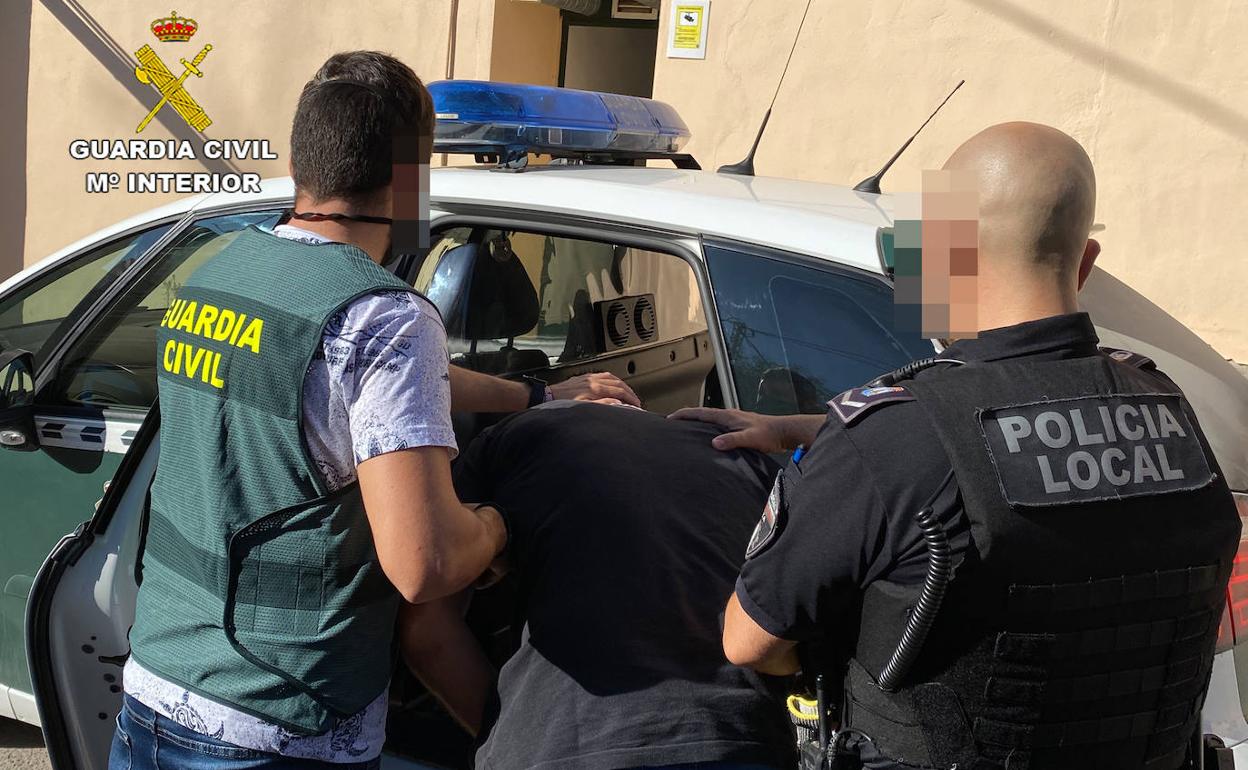 Un agente de la Guardia Civil y otro de la Policía acompañan al detenido.