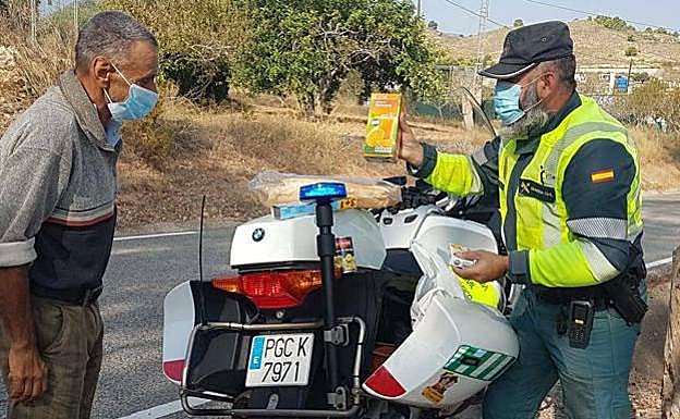 El agente entrega la bolsa con los alimentos. 