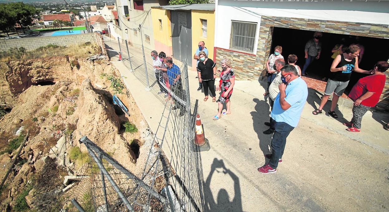 Los vecinos observan el talud dañado, que podría sufrir nuevos desprendimientos ante otro episodio de lluvias. 