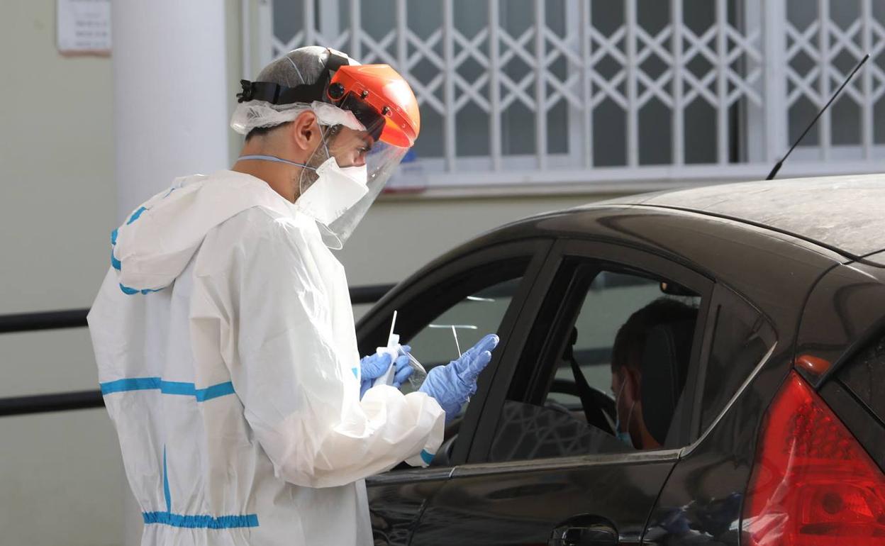 Un sanitario toma muestras a conductores en un Punto Covid de Lorca. 
