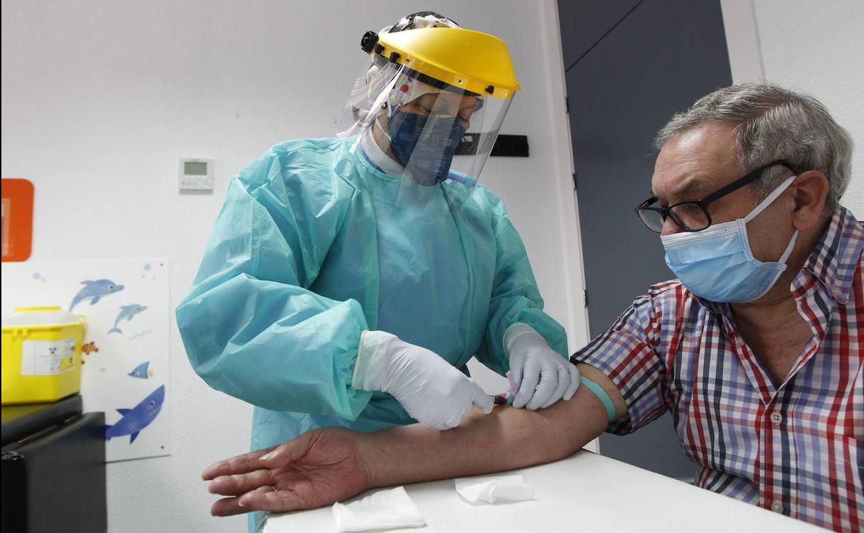 Un sanitario realiza un test rápido a un paciente, en una fotografía de archivo.