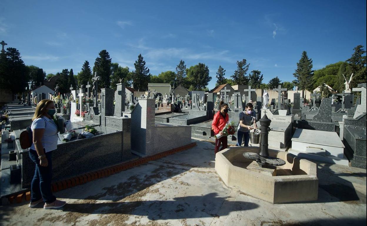 Una familia recoge agua de una de las fuentes del cementerio de Jesús, este miércoles, en Murcia.