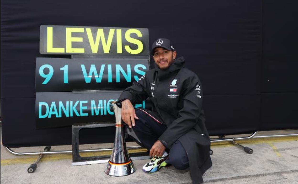 Lewis Hamilton posa junto a un cartel que conmemora sus 91 victorias en la Fórmula 1. 