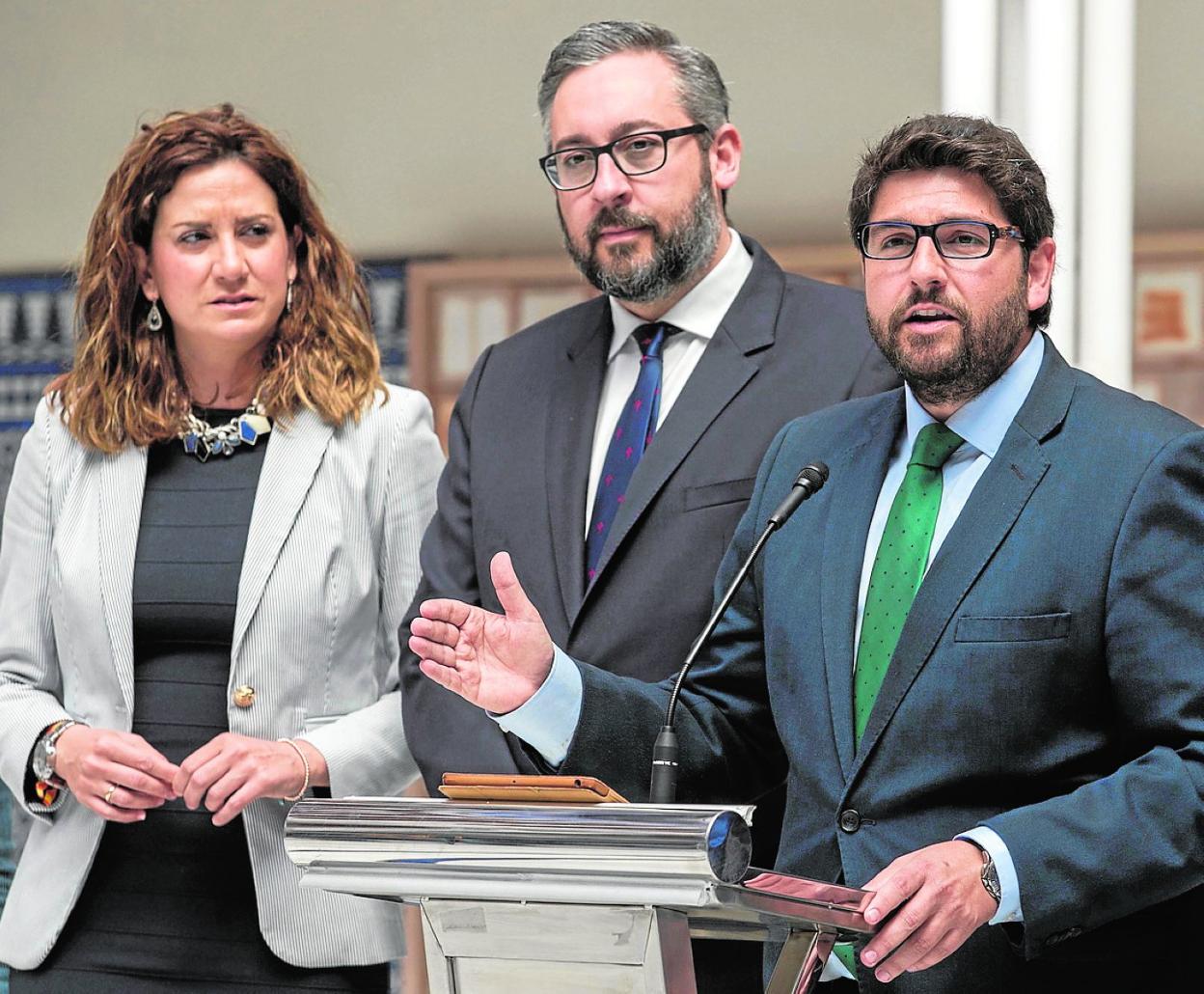 Patricia Fernández, en presencia de Víctor Martínez, observa a López Miras en la Asamblea. 