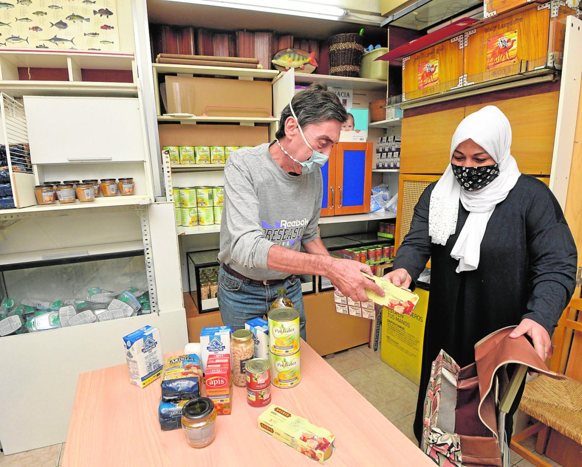 Juan José González entrega alimentos a una beneficiaria de la asociación. 