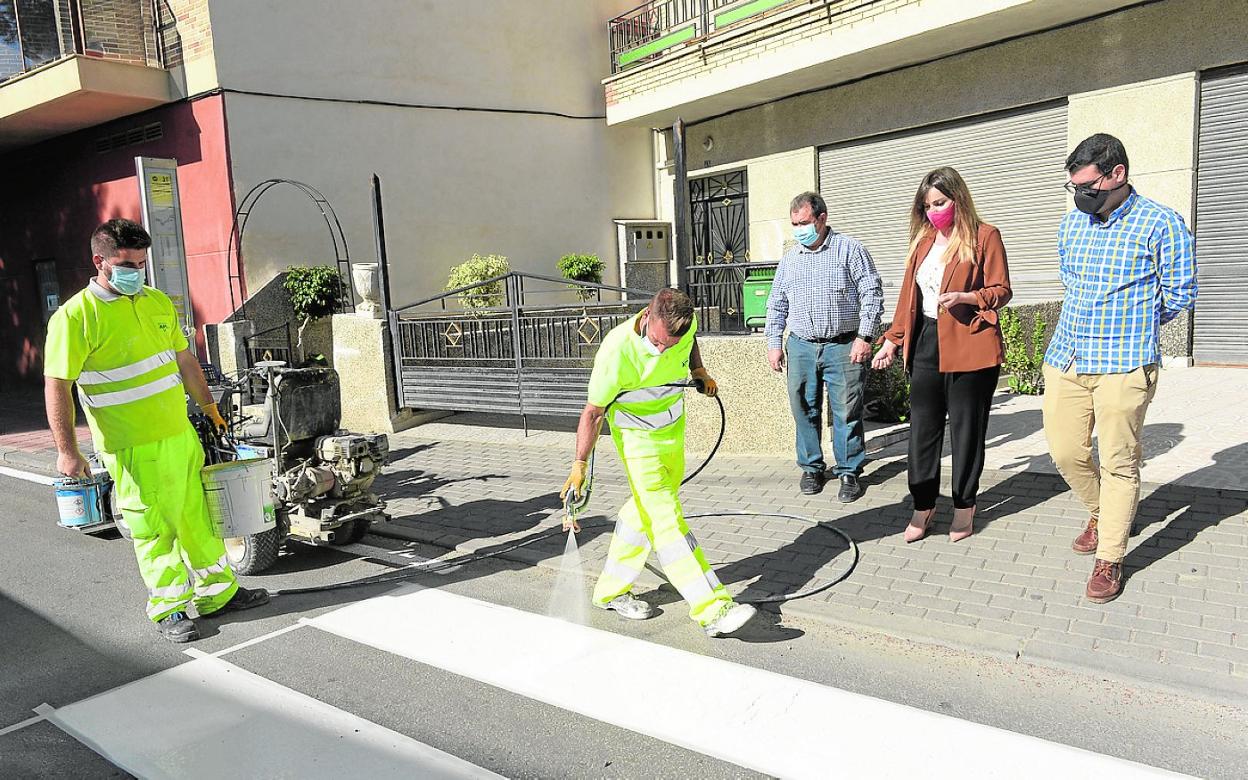 Operarios repintan, este miércoles, en la calle Mayor de la pedanía de Santa Cruz. 